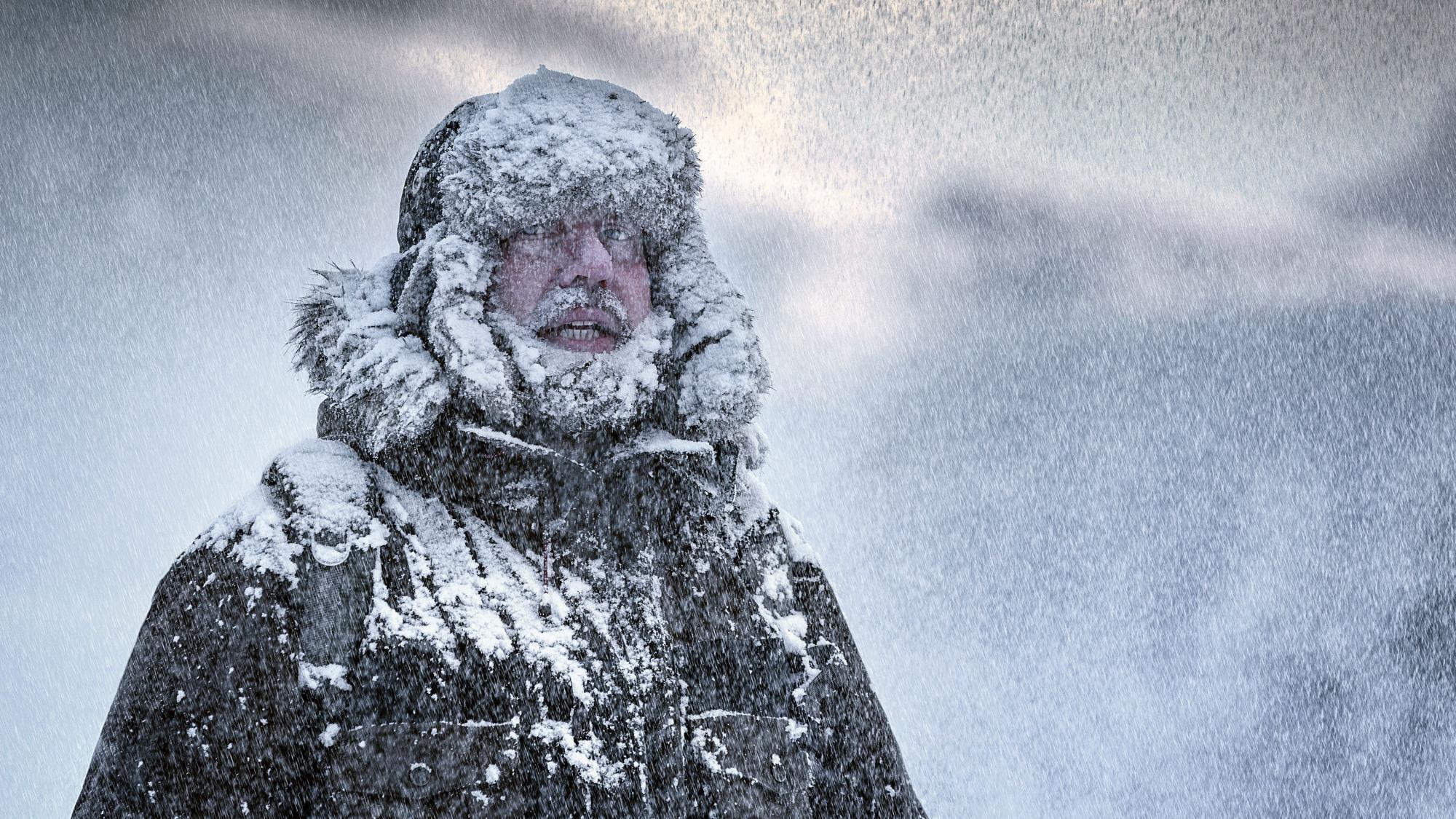Verschneiter Mann im Winteroutfit.