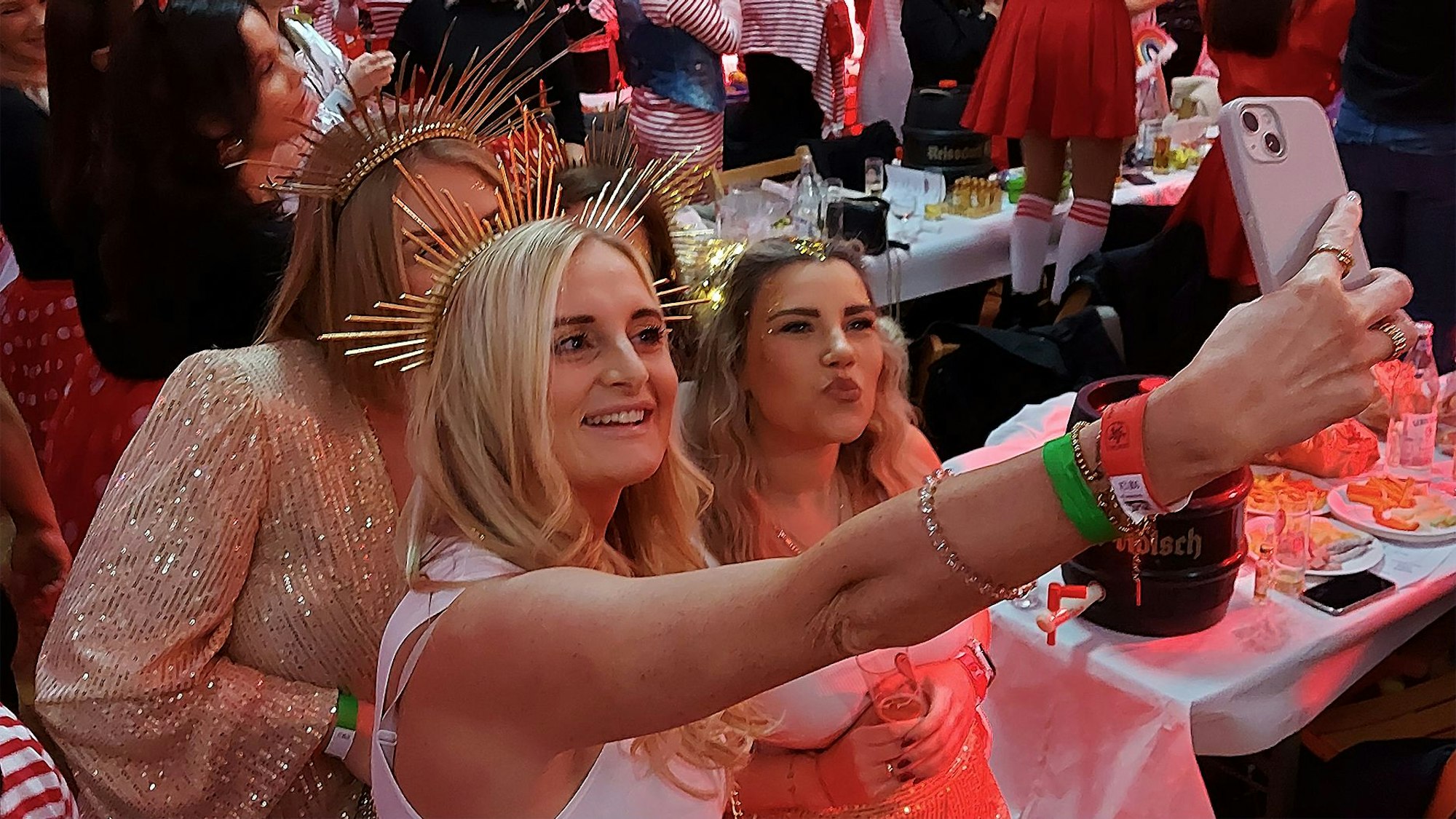 Drei als Sonnengöttinnen verkleidete Frauen machen ein Selfie.