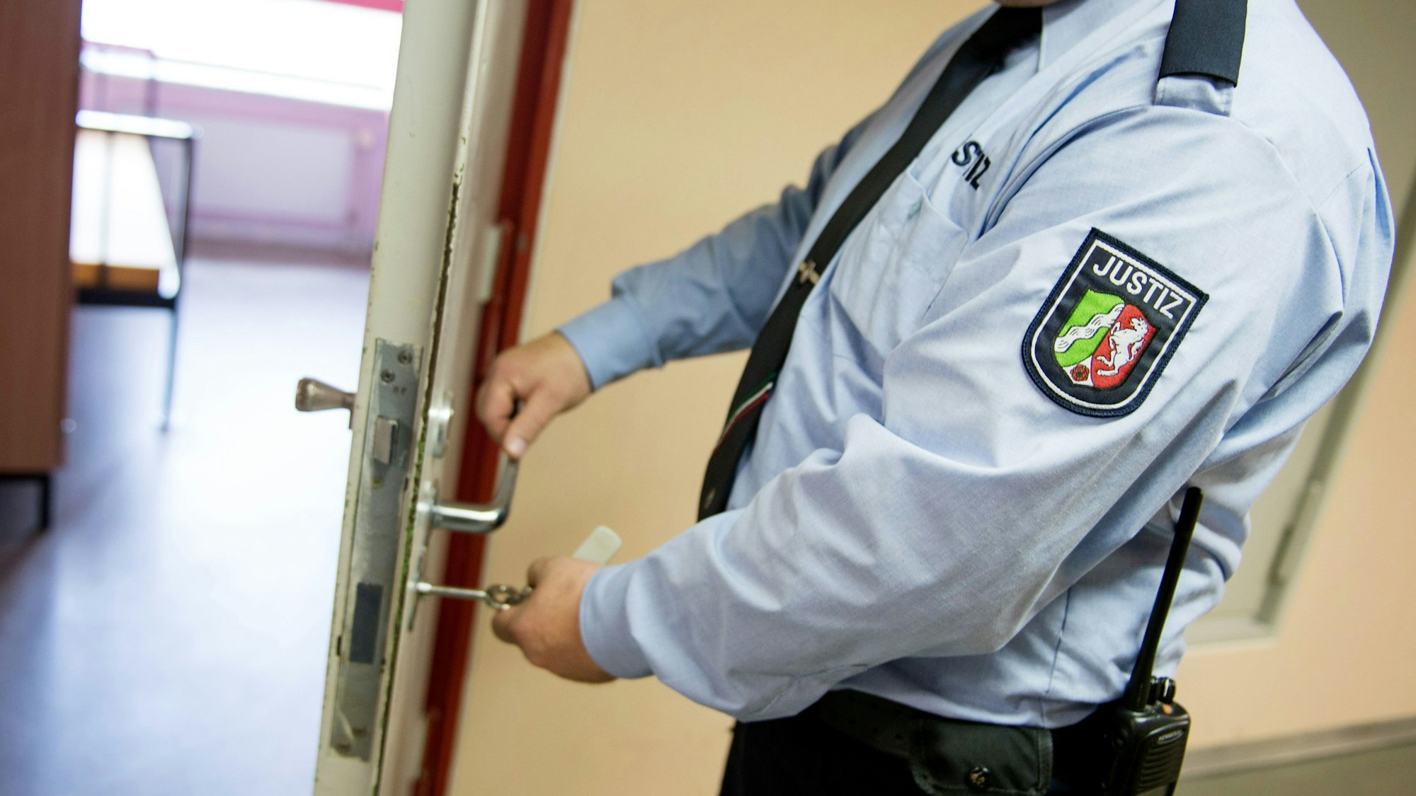 ARCHIV - ILLUSTRATION - 28.07.2014, Nordrhein-Westfalen, Euskirchen: Ein Justizvollzugsbeamter schließt in der Justizvollzugsanstalt eine Tür. Aus der JVA Euskirchen sind möglicherweise sensible Daten über die Vollzugsbeamten in die Hände von Häftlingen geraten. Ein JVA-Mitarbeiter soll Personaldaten auf einen USB-Stick gezogen und diesen auf dem Parkplatz verloren haben, sagte ein Sprecher des NRW-Justizministeriums am 03.07. in Düsseldorf. Foto: Marius Becker/dpa +++ dpa-Bildfunk +++