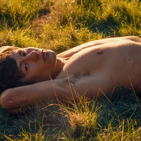 Barry Keoghan streckt sich in einer Szene von „Saltburn“ mit freiem Oberkörper im Gras aus.