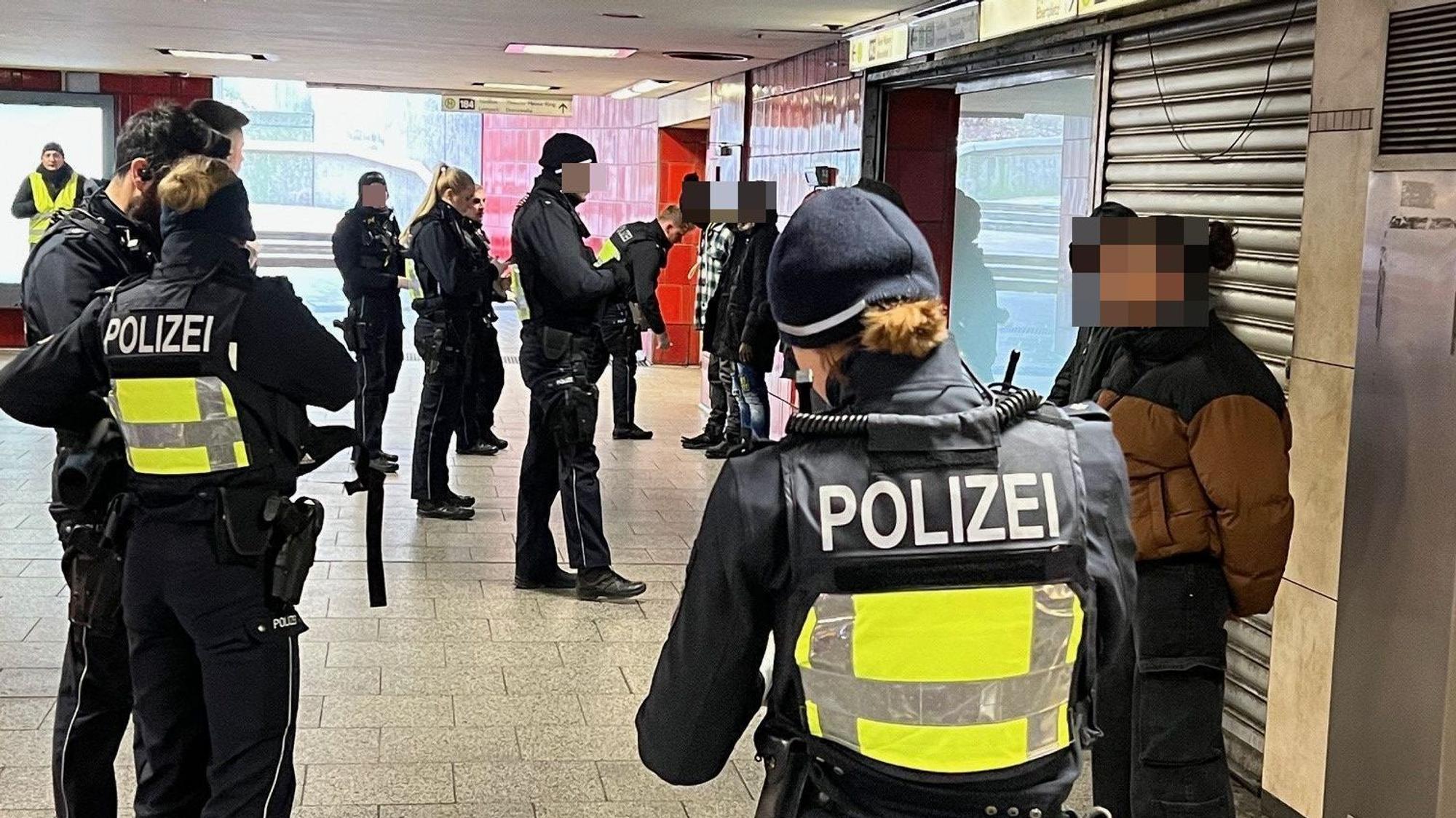 Polizisten durchsuchen mehrere mutmaßliche Drogendealer oder deren Kunden, die mit dem Rücken zu einer Wand in der KVB-Zwischenebene am Ebertplatz stehen.
