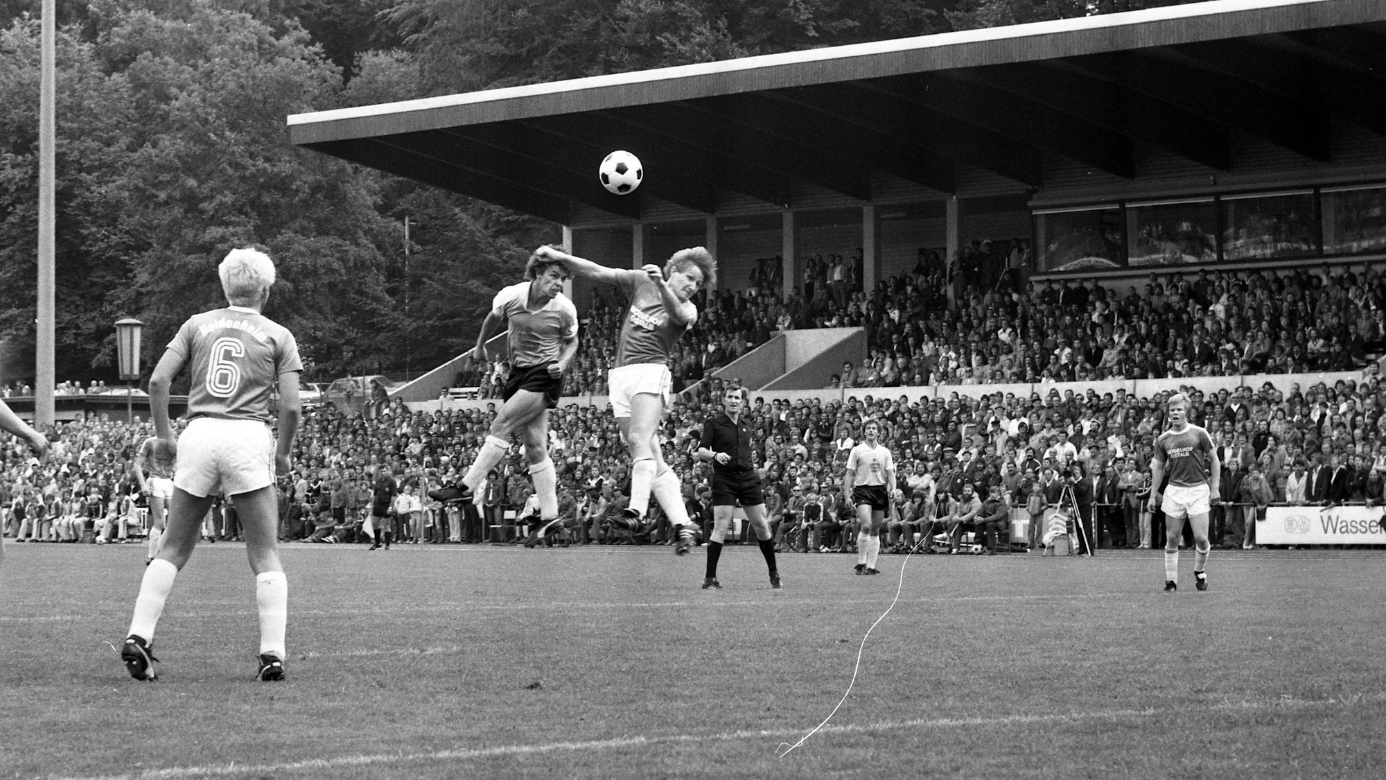 Auf der Schwarz-Weiß-Fotografie ist eine Spielszene zwischen dem Heidenheimer SB und Hertha BSC zu sehen. Zwei Spieler liefern sich in der Mitte ein Kopfballduell.