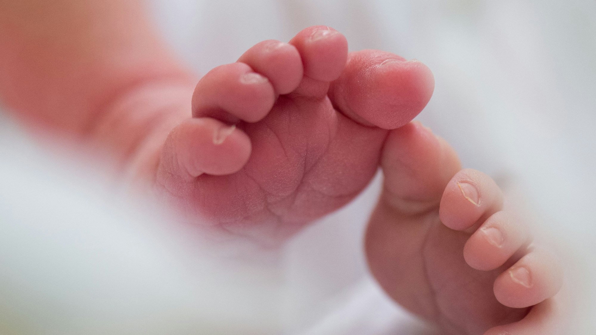 Ein Säugling liegt am in einem Bett auf der Wochenstation in einem Universitätsklinikum. (Symbolbild)