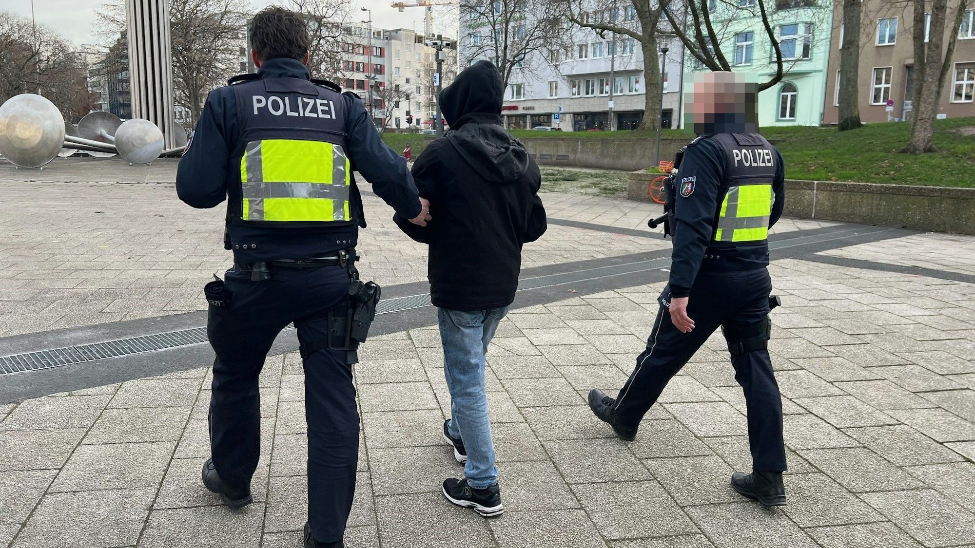 Zwei uniformierte Polizisten führen bei der Razzia am 10.01.2024 eine verdächtige Person auf dem Ebertplatz ab.