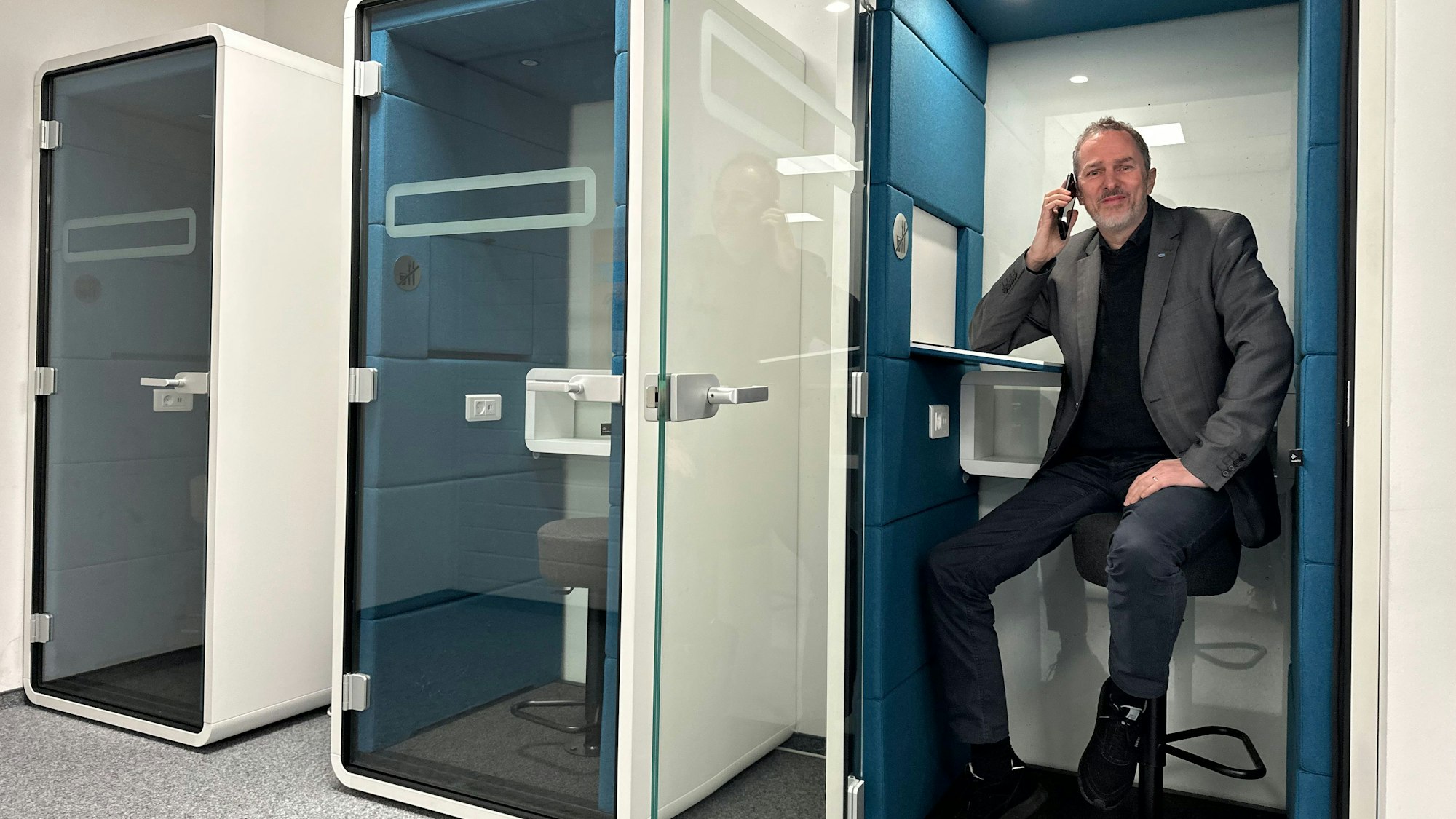 Professor Marco Winzker, Vizepräsident Hochschule Bonn-Rhein-Siegburg für Studium, Lehre und Weiterbildung, in einer modernen und schalldichten Telekommunikationskabine, früher Telefonzelle genannt, in Hochschulbibliothek.