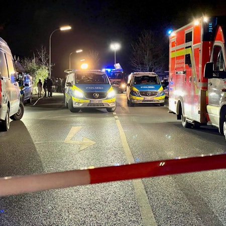 Ein Polizeiwagen und ein Rettungswagen stehen bei einem Einsatz nebeneinander.