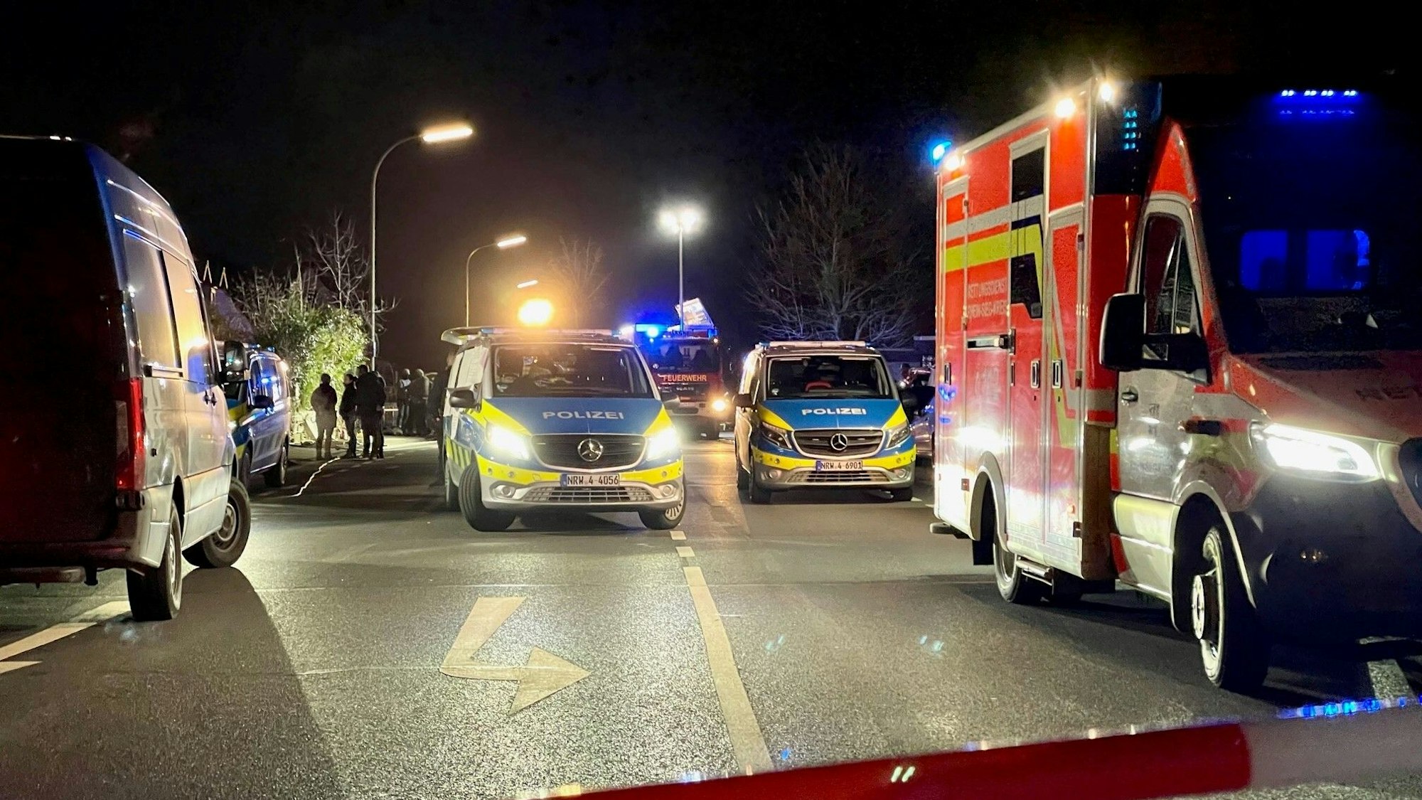 Ein Polizeiwagen und ein Rettungswagen stehen bei einem Einsatz nebeneinander.