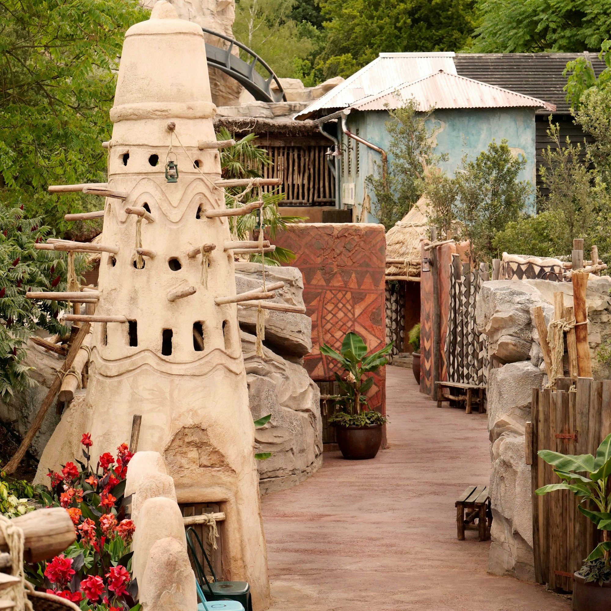 Der Pfad in „Deep in Africa“ führt vorbei an Steinmauern, Lehmtürmen, Bananenpflanzen und rustikalen Holzbänken.