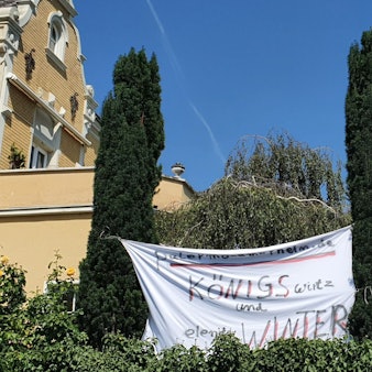 Zwischen Bäumen sind weiße Tücher gespannt, auf denen unter anderem „Bürger machen mobil“ geschrieben steht.