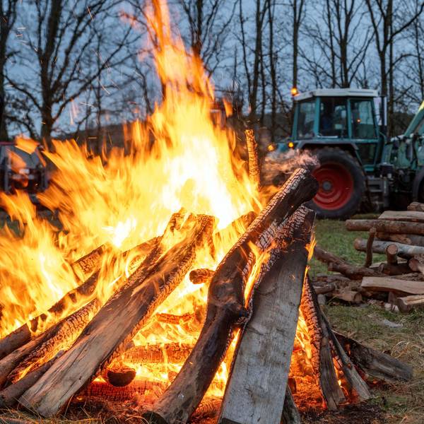 05.01.2024, Bayern, Burgpreppach: Ein Schlepper fährt an einem Feuer vorbei. An der Bundesstraße 303 in Burgpeppach sowie rund 14 weiteren Orten in Franken demonstrieren Landwirte am Freitagabend mit Mahnfeuern unter dem Motto "Franken in Flammen" gegen geplante Kürzungen der Agrardiesel-Subventionen und die Abschaffung von Kfz-Steuererleichterungen in der Land- und Forstwirtschaft. Foto: Pia Bayer/dpa +++ dpa-Bildfunk +++