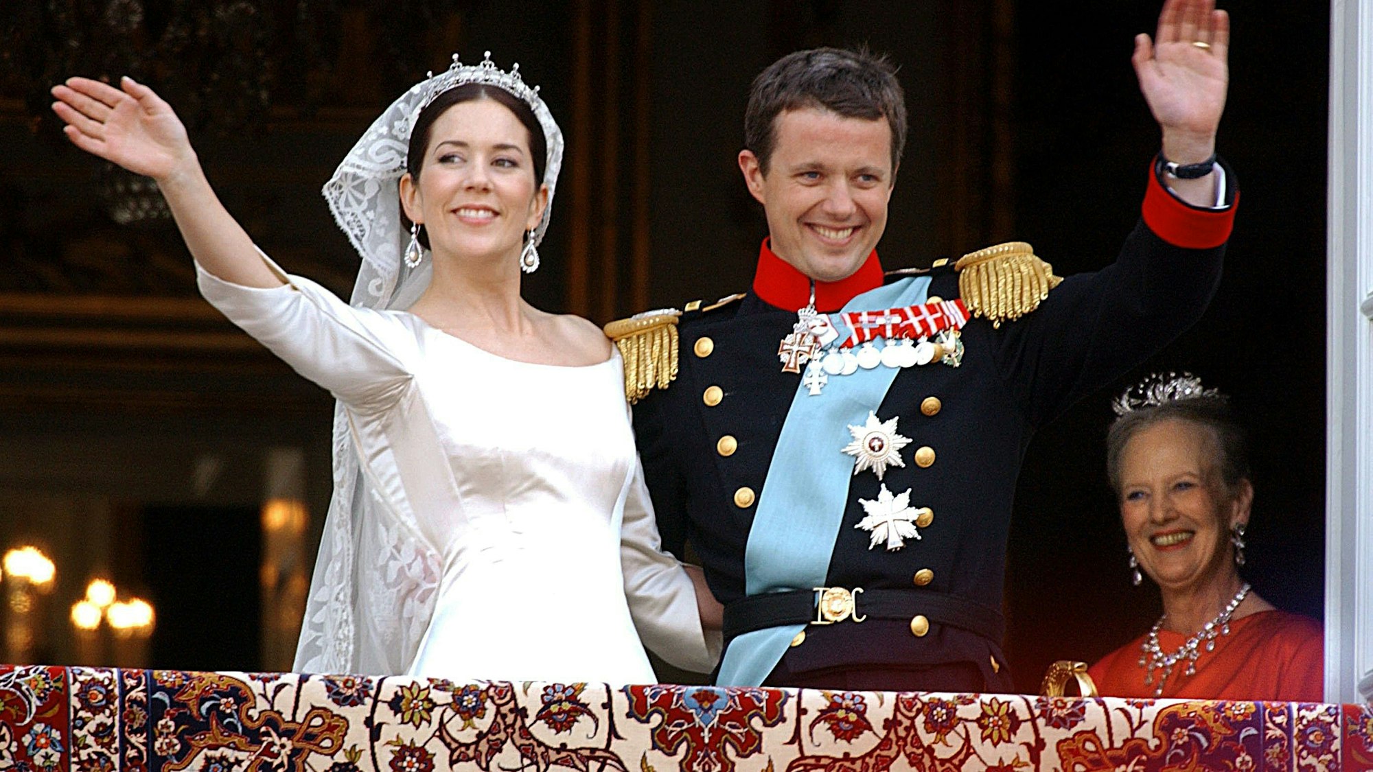 Der dänische Kronprinz Frederik (r) und seine frisch angetraute Frau Prinzessin Mary am Freitag (14.05.2004) auf dem Balkon von Schloss Amalienborg der Menge zu. Rechts im Hintergrund die dänische Königin Margrethe.