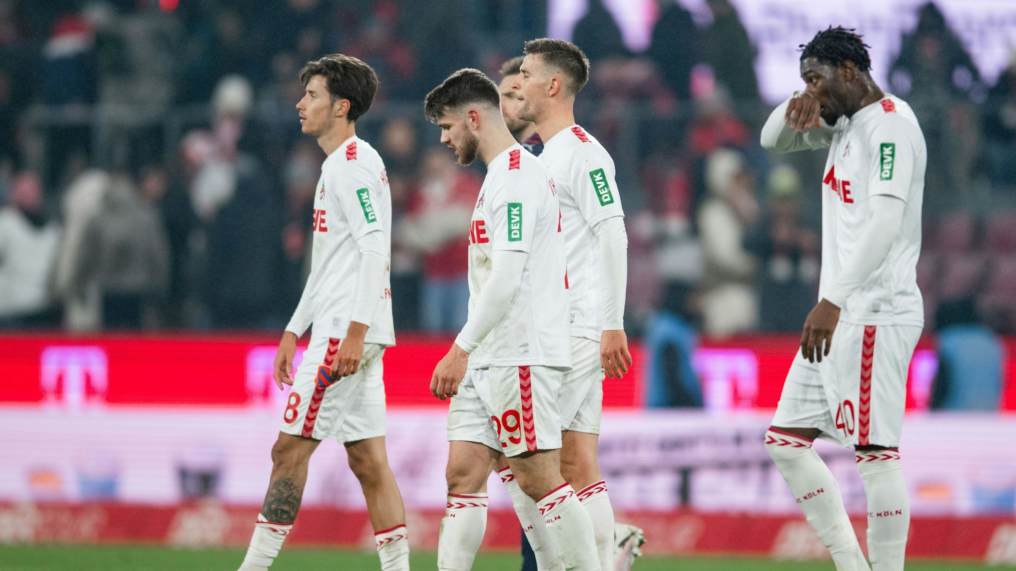 Die Kölner Denis Huseinbasic (l-r), Jan Thielmann und Faride Alidou verlassen nach der Partie den Rasen.