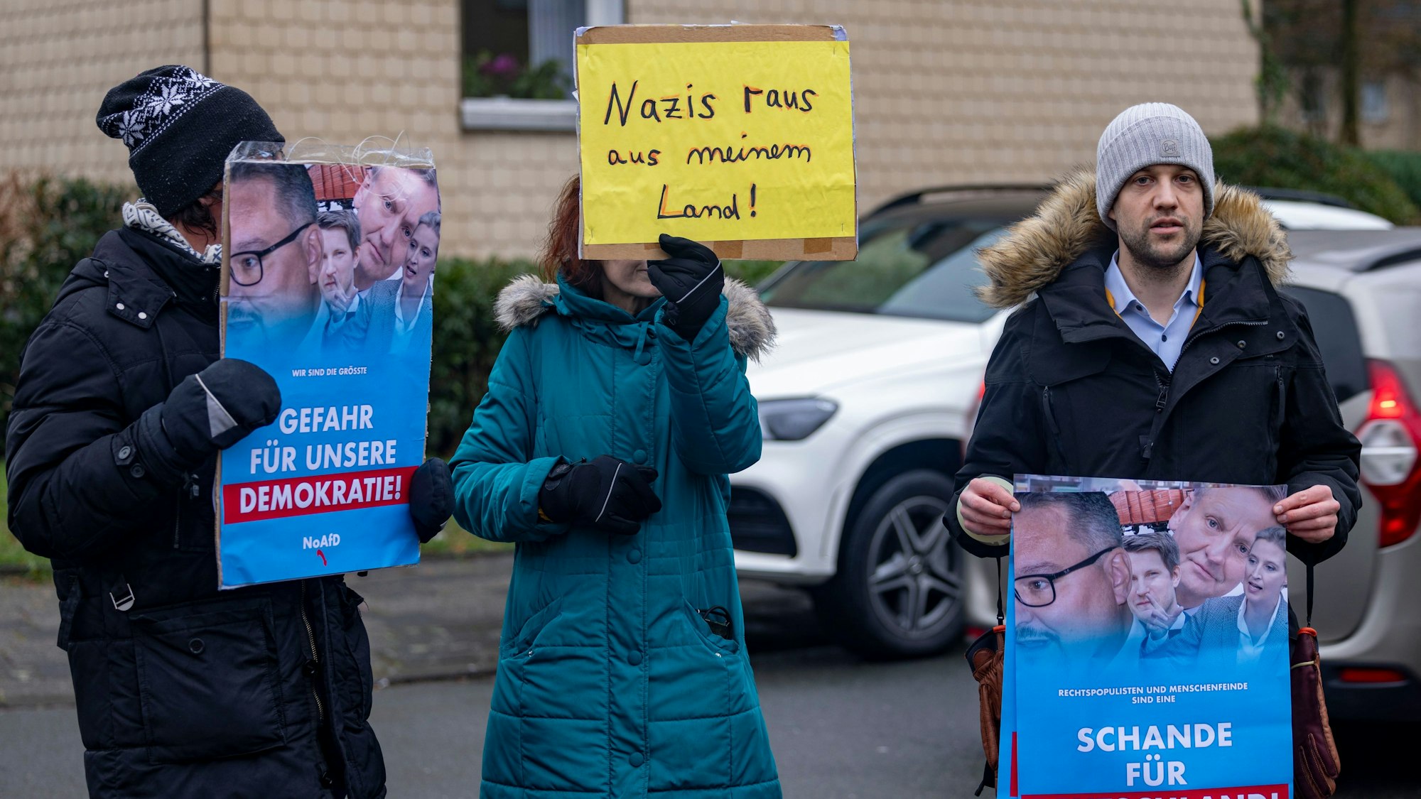 Drei Personen demonstrieren mit Plakaten gegen den Neujahrsempfang der AfD in Duisburg.