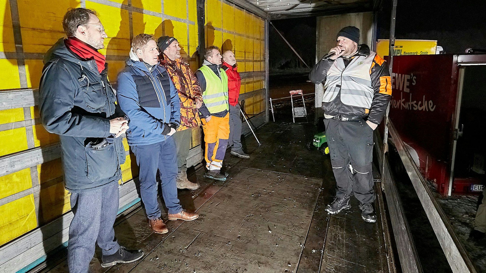 Sechs Männer stehen bei einer Demonstration auf einem Lkw-Anhänger, rechts Landwirt Thomas Gräf. Er spricht in ein Mikrofon.