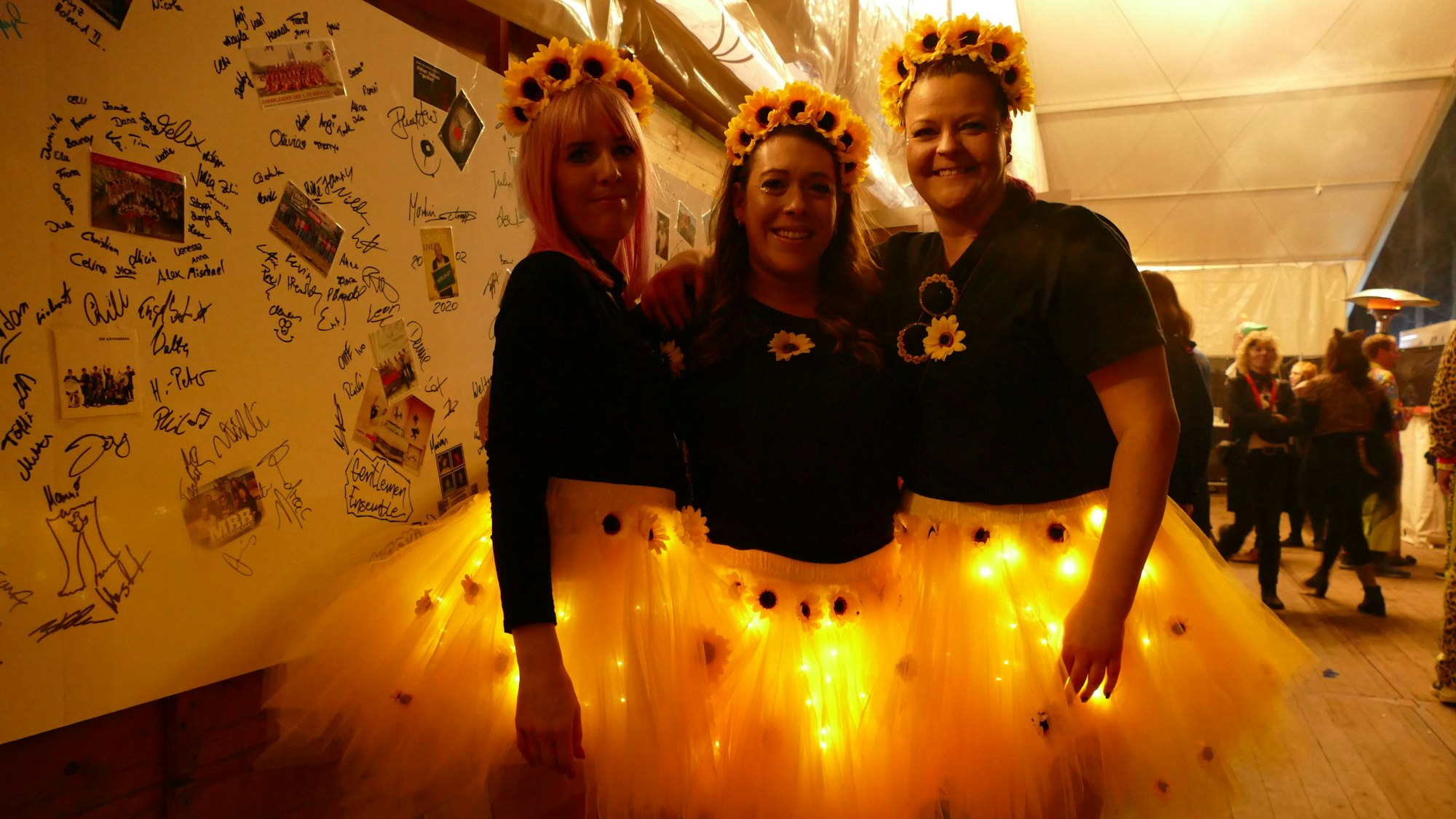 Drei Frauen als Sonnenblumen verkleidet.