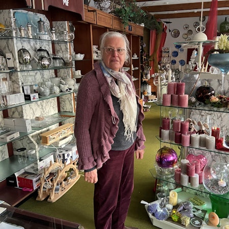 Eine Frau steht in einem Verkaufsraum voller Dekoartikel und Haushaltswaren.