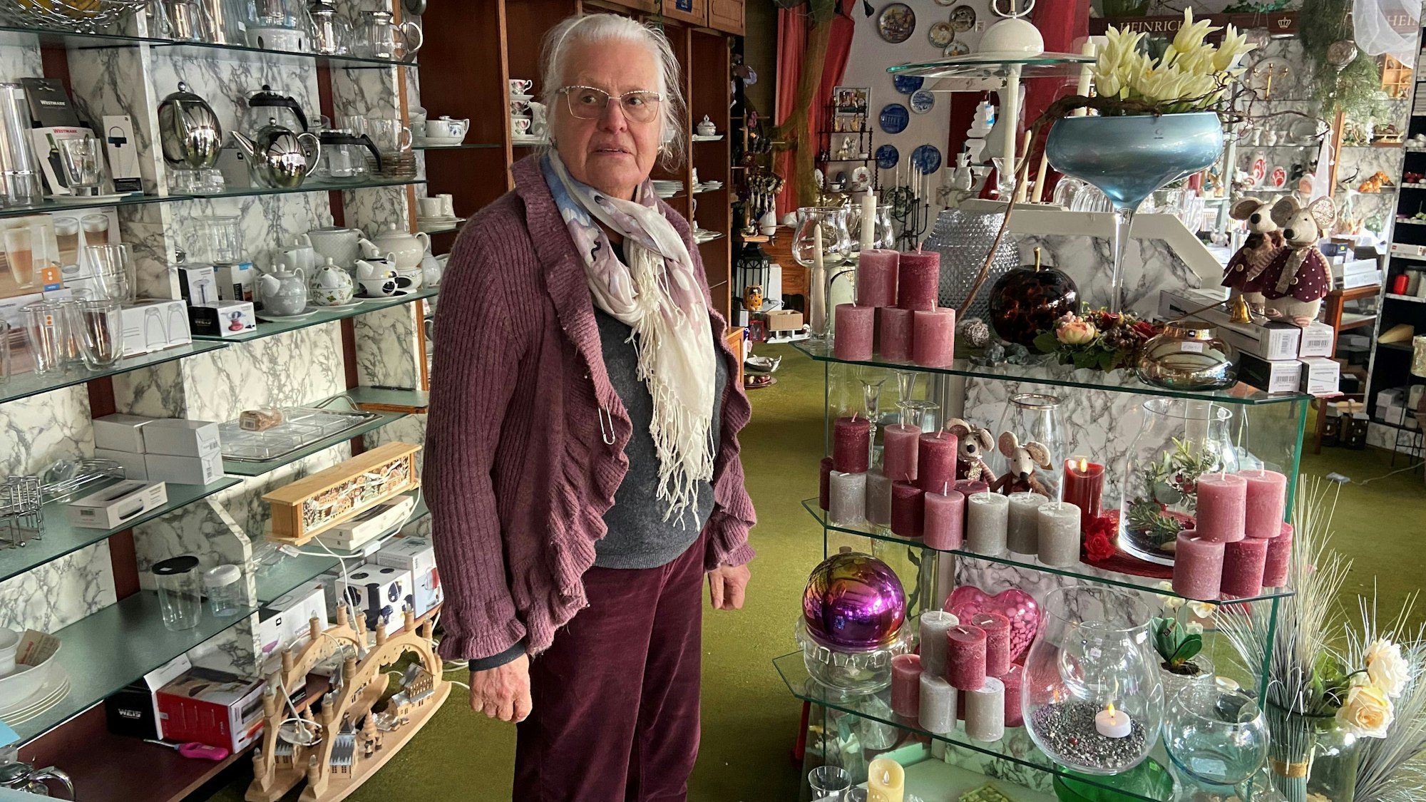 Eine Frau steht in einem Verkaufsraum voller Dekoartikel und Haushaltswaren.