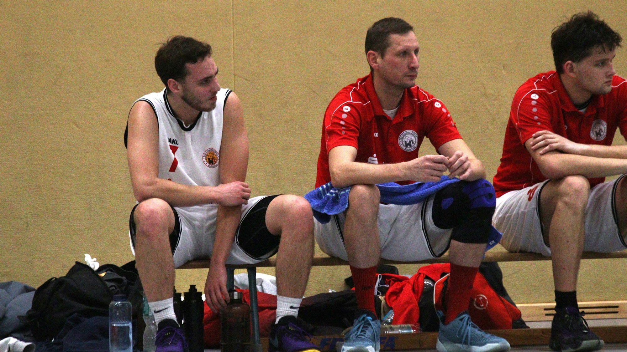 Tobias Kehren sitzt auf der Bank und hält sich mit schmerzverzerrtem Gesicht den linken Arm.