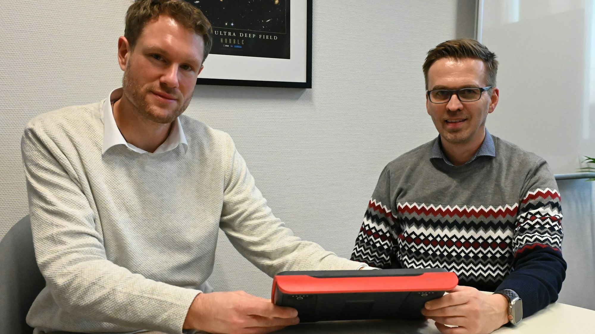 Thomas Mann, der ärztliche Leiter des Rettungsdienstes im Kreis Euskirchen, und Martin Fehrmann, Leiter der Gefahrenabwehr, sitzen an einem Tisch und betrachten ein Tablet.