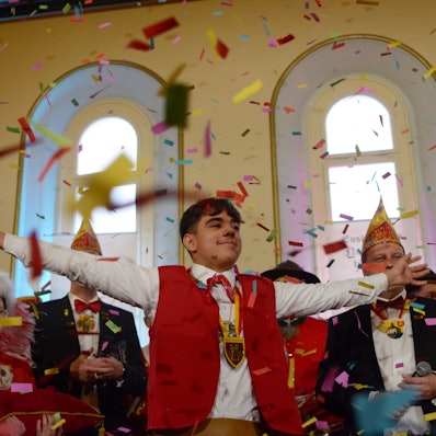 Der neue Euskirchener Küfer Ricardo steht mit anderen Karnevalisten und Bürgermeister Sacha Reichelt im Konfettiregen auf der Bühne des Casinos.