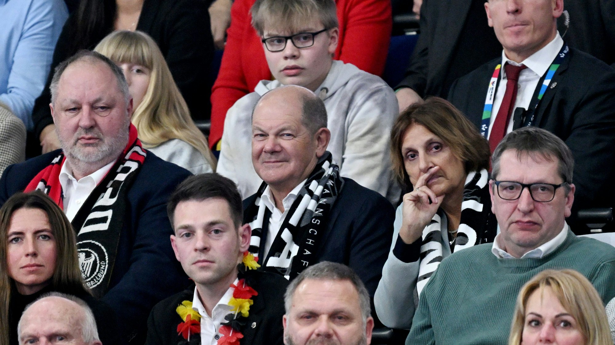 Bundeskanzler Olaf Scholz (M/SPD), seine Frau Britta Ernst (r) und DHB-Präsident Andreas Michelmann verfolgen das HAndball-Spiel der deutschen Mannschaft in Berlin.