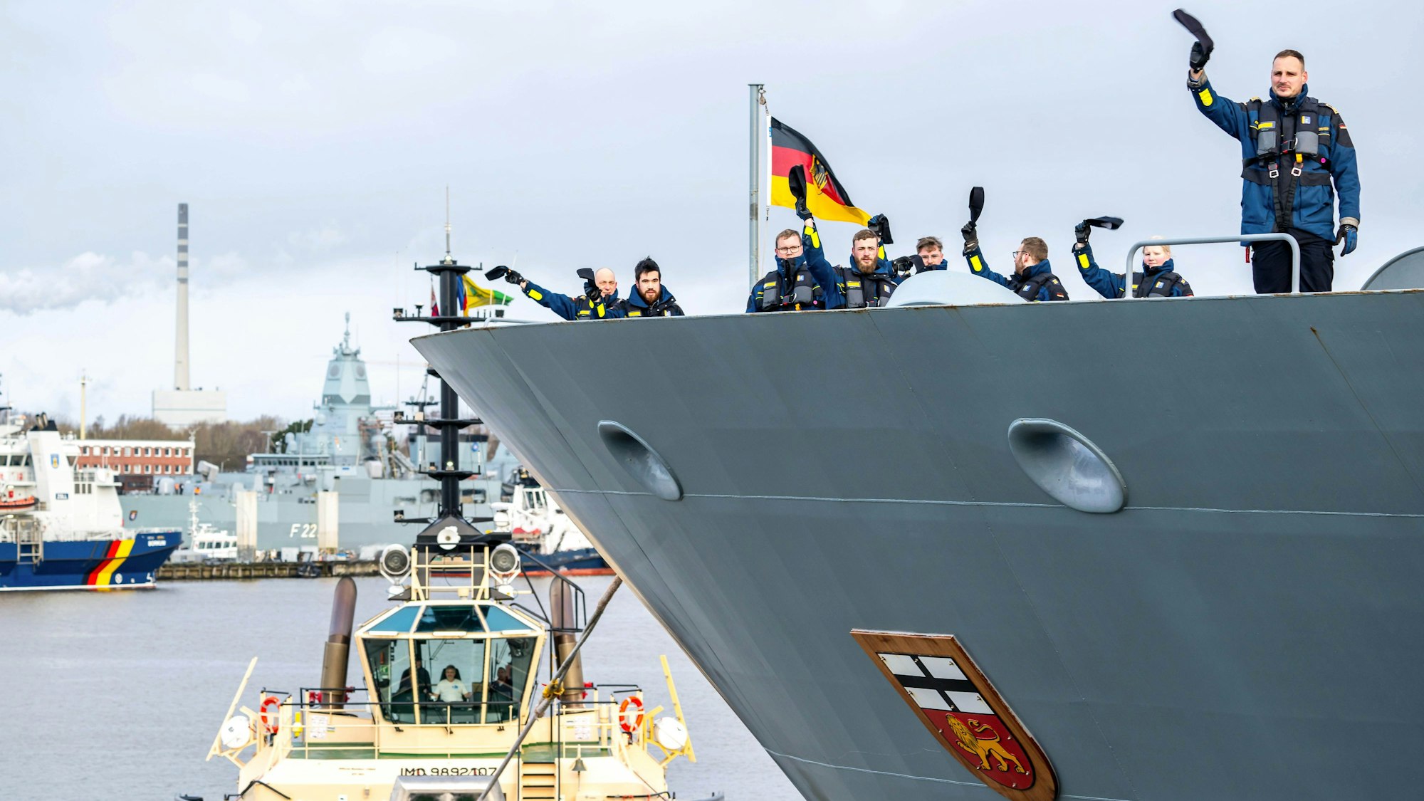 Die Besatzung vom Marineschiff «Bonn» winkt bei der Ausfahrt aus dem Hafen.