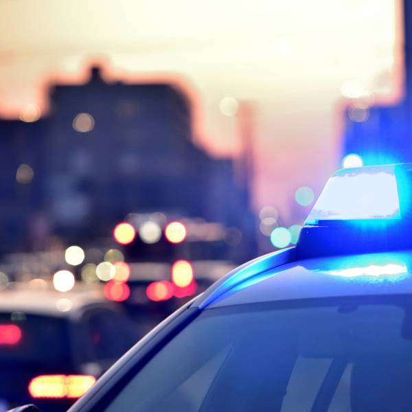 Das Bild zeigt ein Blaulicht auf einem Streifenwagen leuchtet.