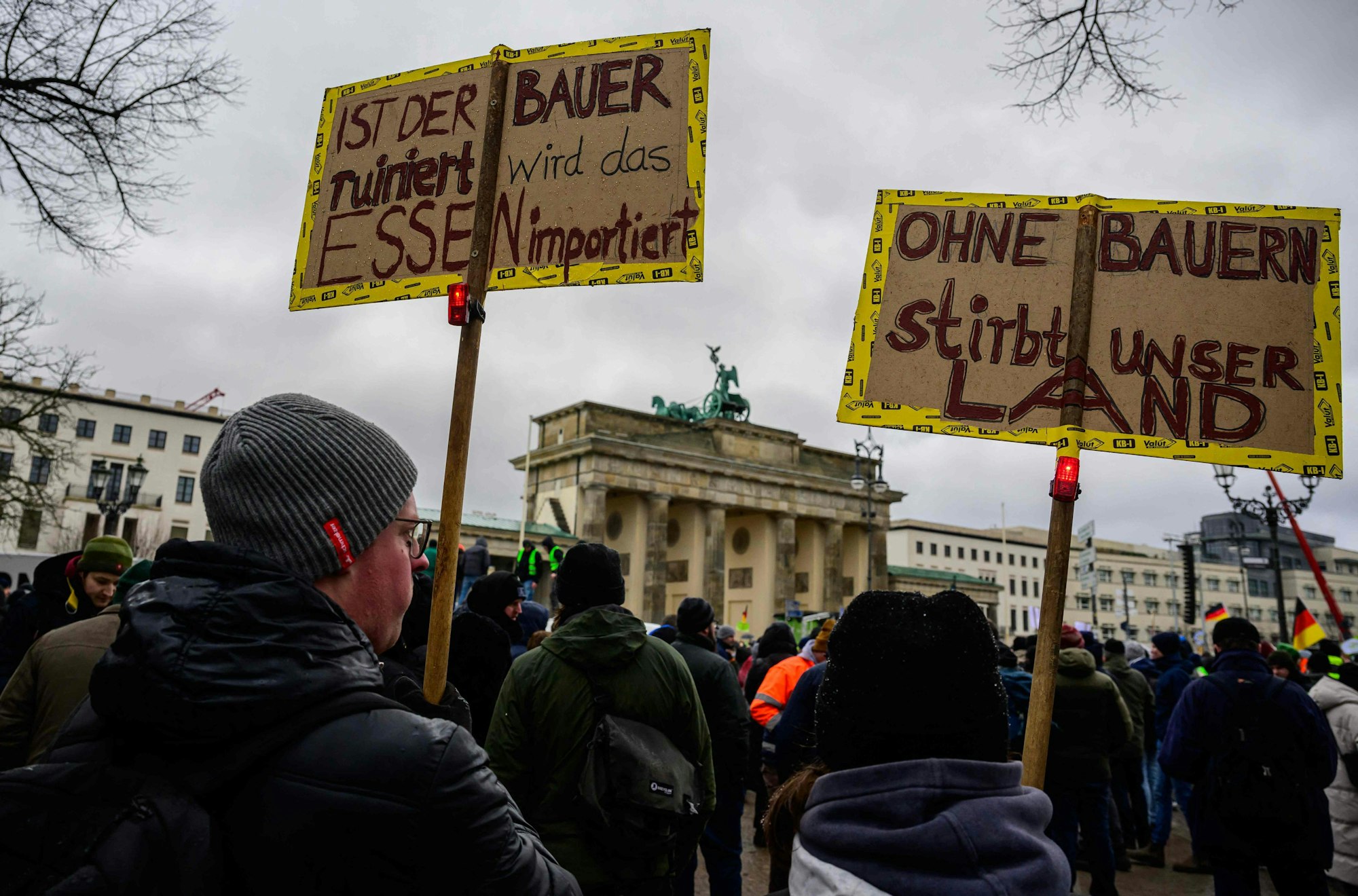 Demonstration von Landwirten am Montag in Berlin vor dem Brandenburger Tor: Demonstrationsteilnehmer zeigen Schilder mit der Aufschrift „Ist der Bauer ruiniert, wird das Essen importiert“ und „Ohne Bauern stirbt unser Land“.