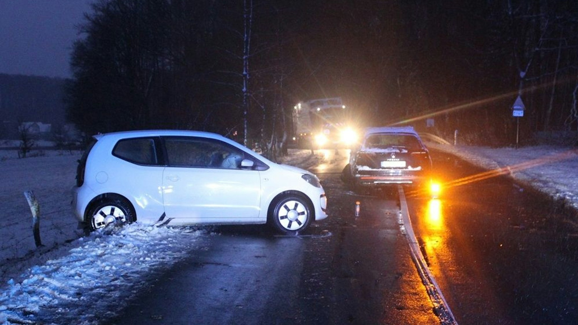 Zwei Unfallautos stehen in der Dämmerung auf einer Straße bei Kürten-Spitze.