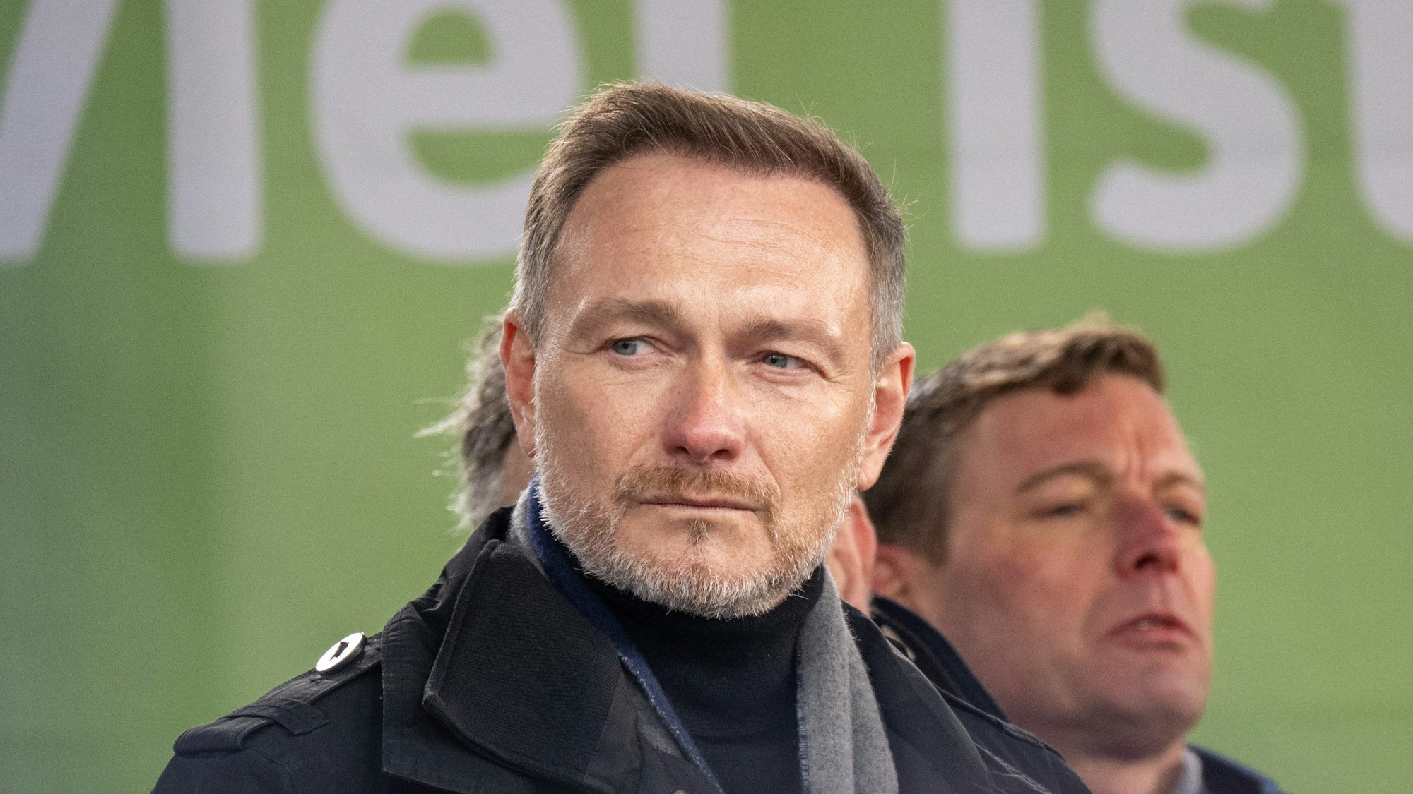 Bundesfinanzminister Christian Lindner steht bei einer Rede während der Bauernproteste in Berlin auf der Bühne am Brandenburger Tor.