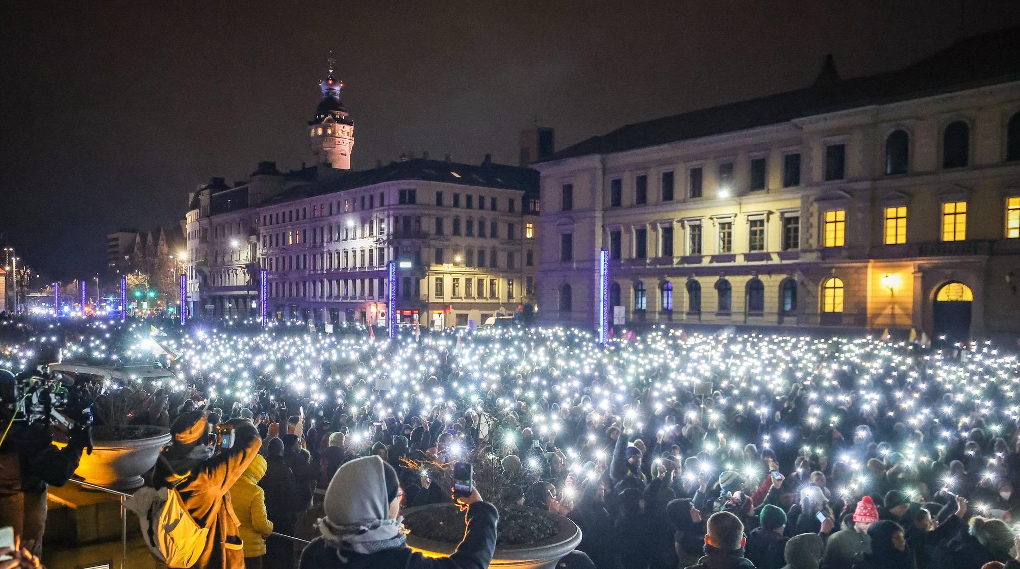 Leipzig: Zahlreiche Teilnehmer leuchten am Montagabend (15. Januar) mit den Taschenlampen ihrer Handys während einer Demonstration gegen die AfD.