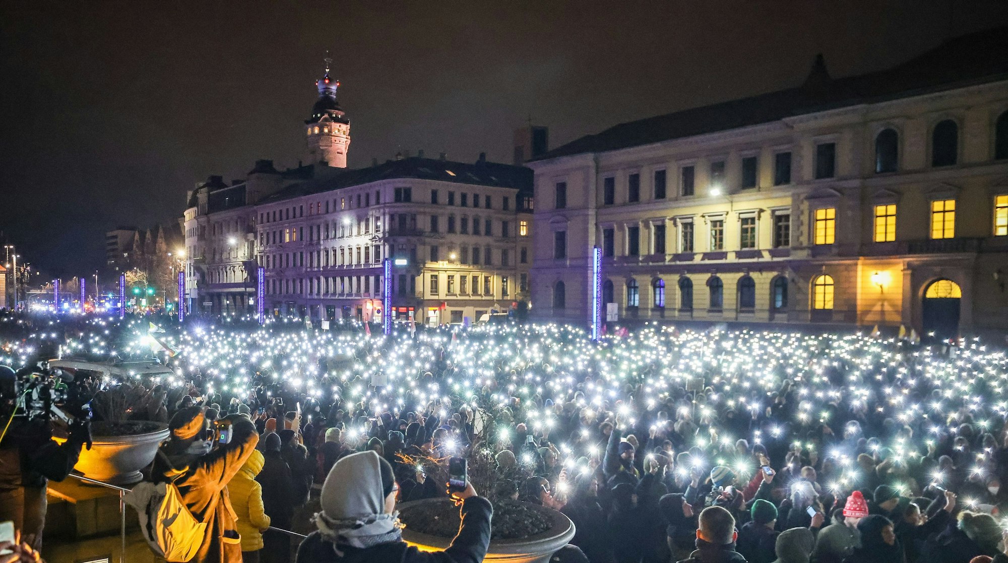 Leipzig: Zahlreiche Teilnehmer leuchten am Montagabend (15. Januar) mit den Taschenlampen ihrer Handys während einer Demonstration gegen die AfD.