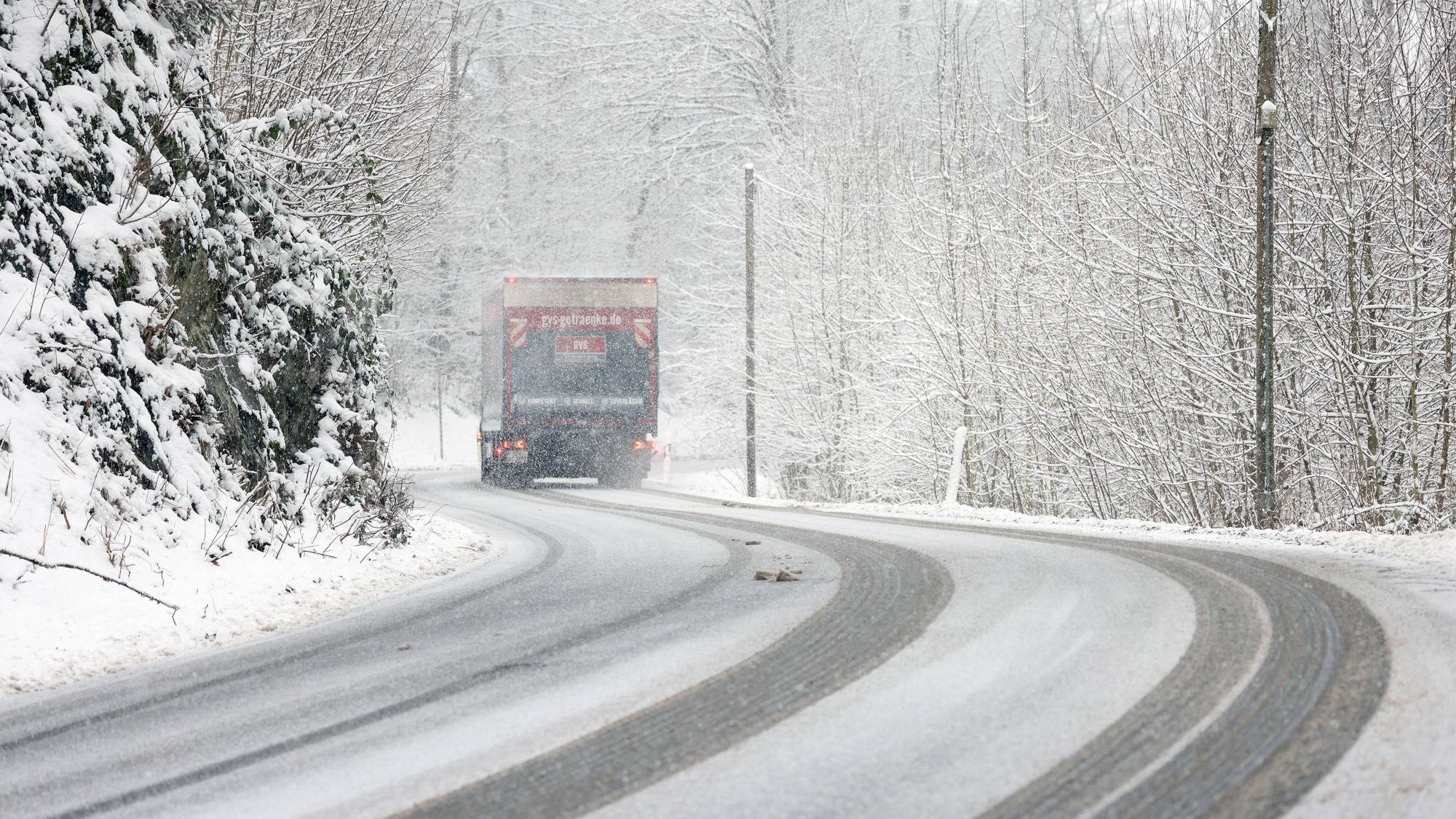Winter im Siegerland. Winterliche Straßenverhältnisse. Ein Lastwagen fährt über die verschneite L907 bei Siegen-Gosenbach.