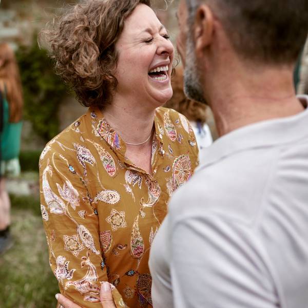 Foto einer lachenden Frau im Gespräch.