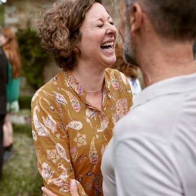 Foto einer lachenden Frau im Gespräch.