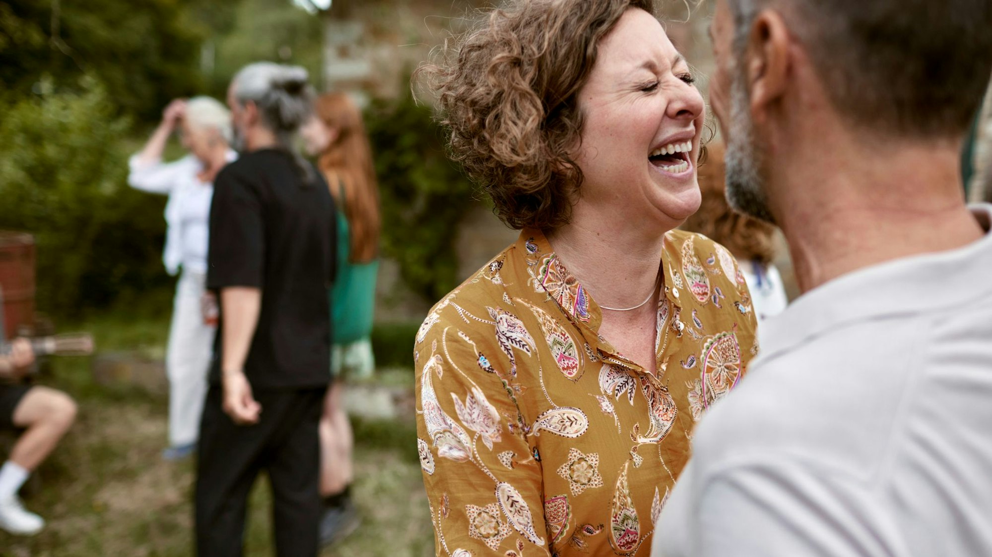 Foto einer lachenden Frau im Gespräch.