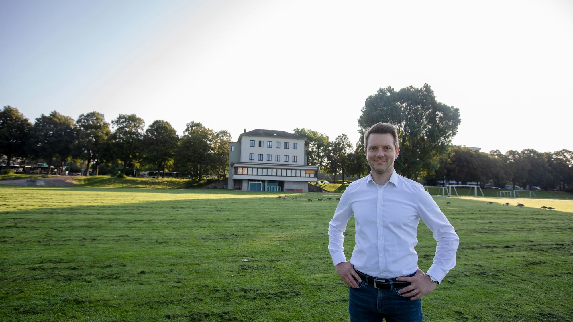 Simon Bujanowski steht vor einem Gebäude mit Umkleiden, das zur Bezirkssportanlage Poll gehört.