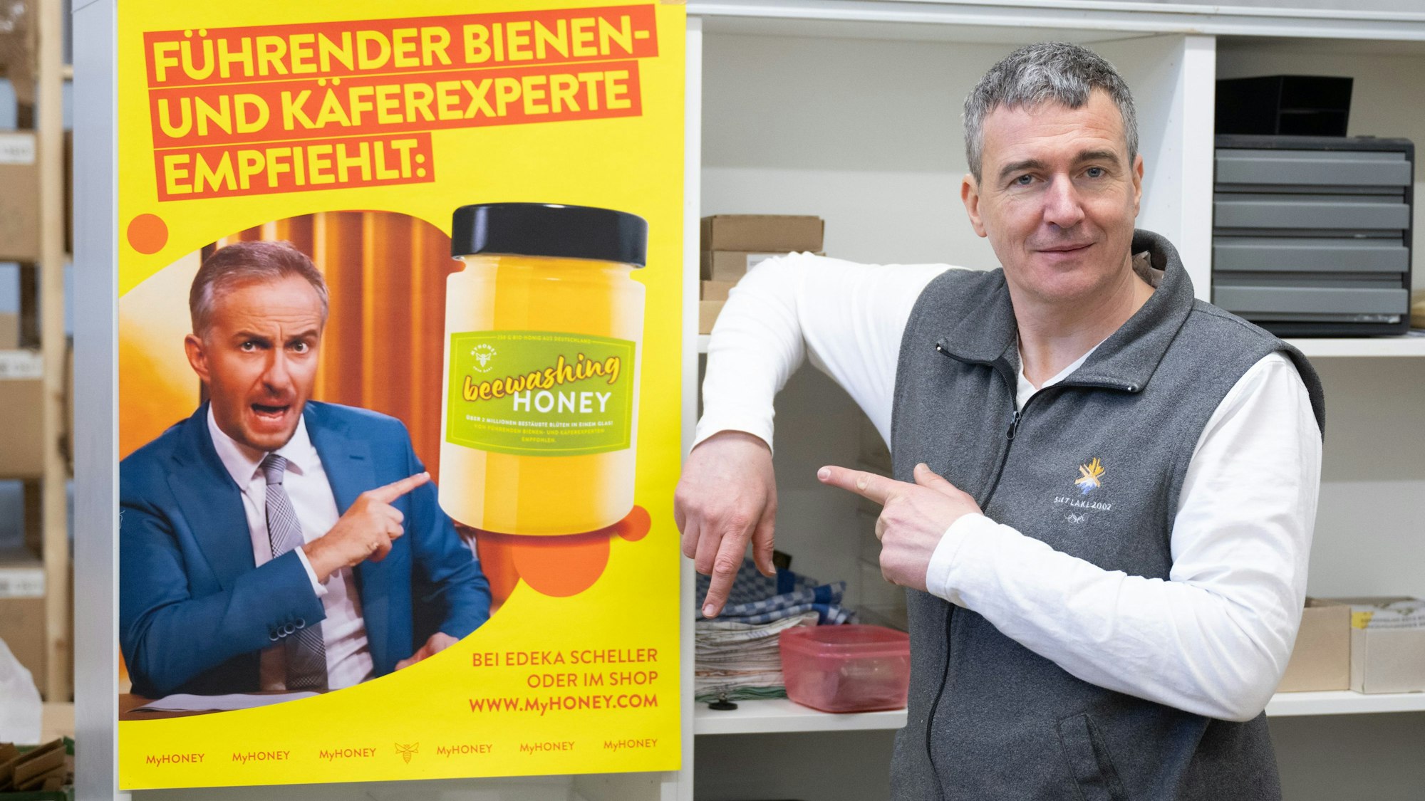 Rico Heinzig, Imker, steht neben einem Plakat mit dem Foto des Moderators Jan Böhmermann. Böhmermann verklagt den Imker.