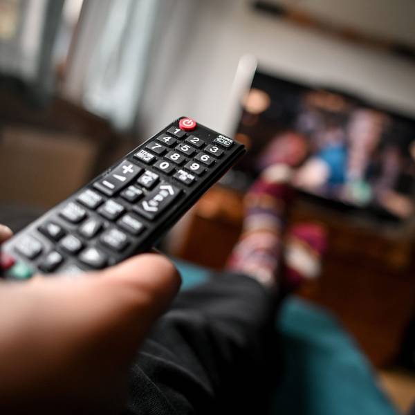 Eine Fernbedienung zeigt in Richtung eines Fernsehers.