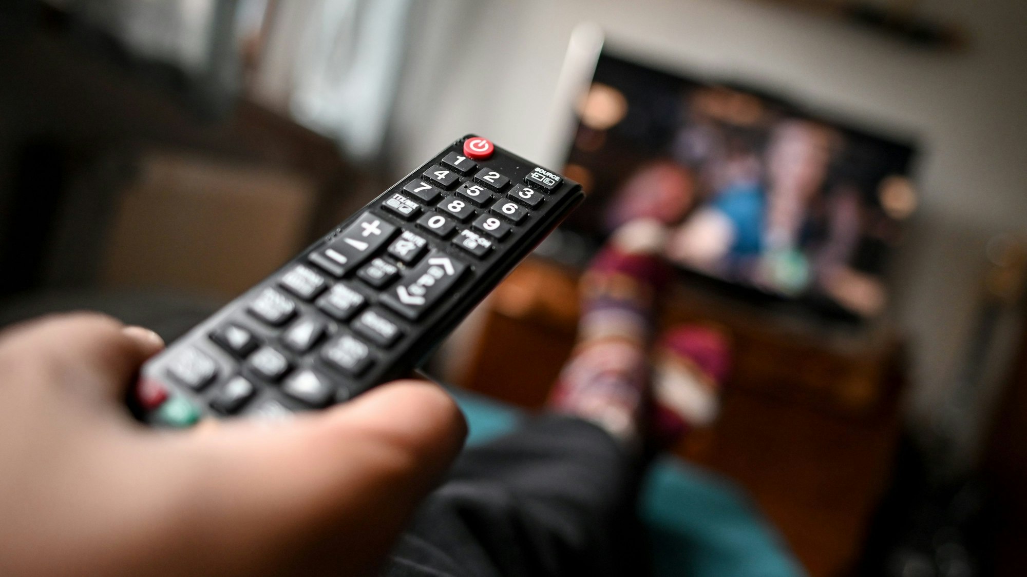 Eine Fernbedienung zeigt in Richtung eines Fernsehers.