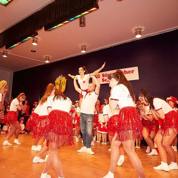 Frauen der Showtanzgruppe IG Ländchen tanzen in roten Röcken und weißen T-Shirts auf der Bühne.