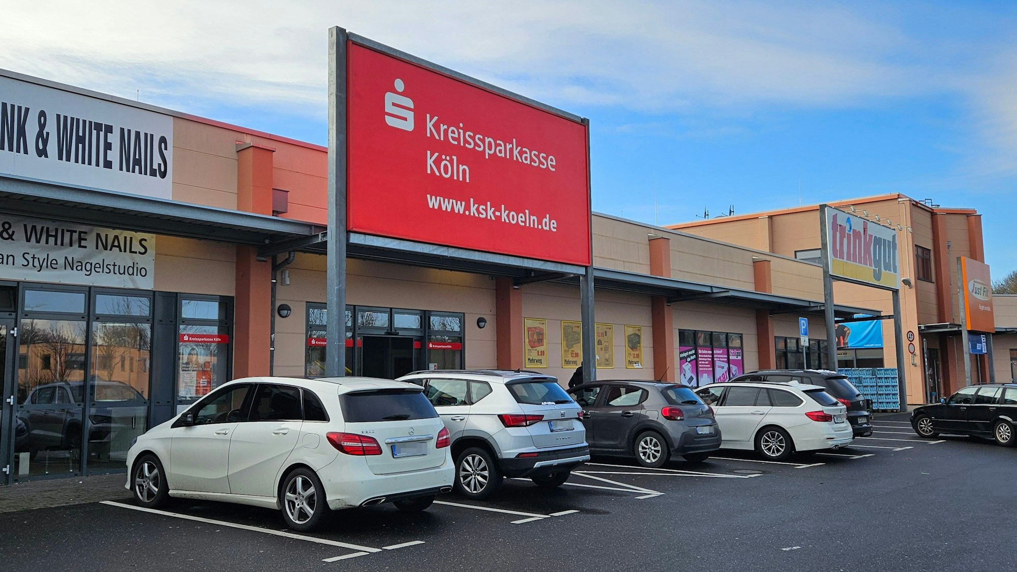 Vor einer Niederlassung der Kreissparkasse Köln parken Autos.