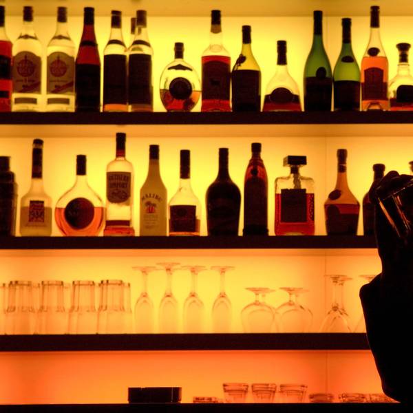 Ein Bar-Besucher sitzt vor einer bunt beleuchteten Bar. (Symbolfoto)