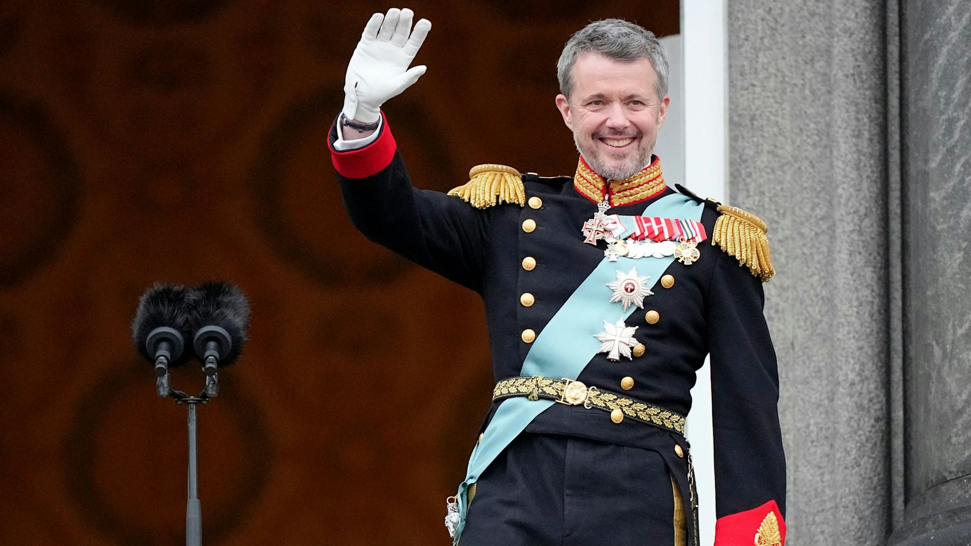 Dänemarks König Frederik X. winkt vom Balkon des Schlosses Christiansborg.