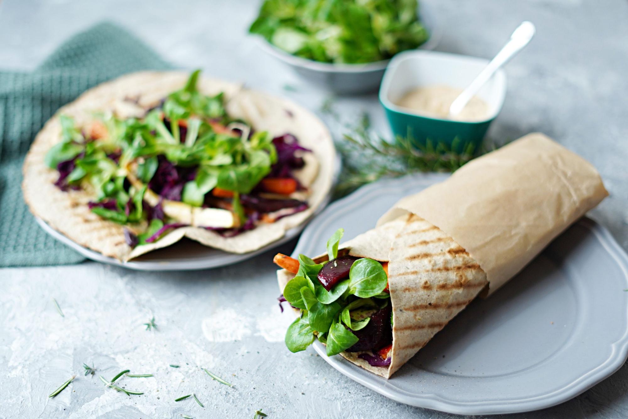 Aus einem Wrap guckt Feldsalat raus.