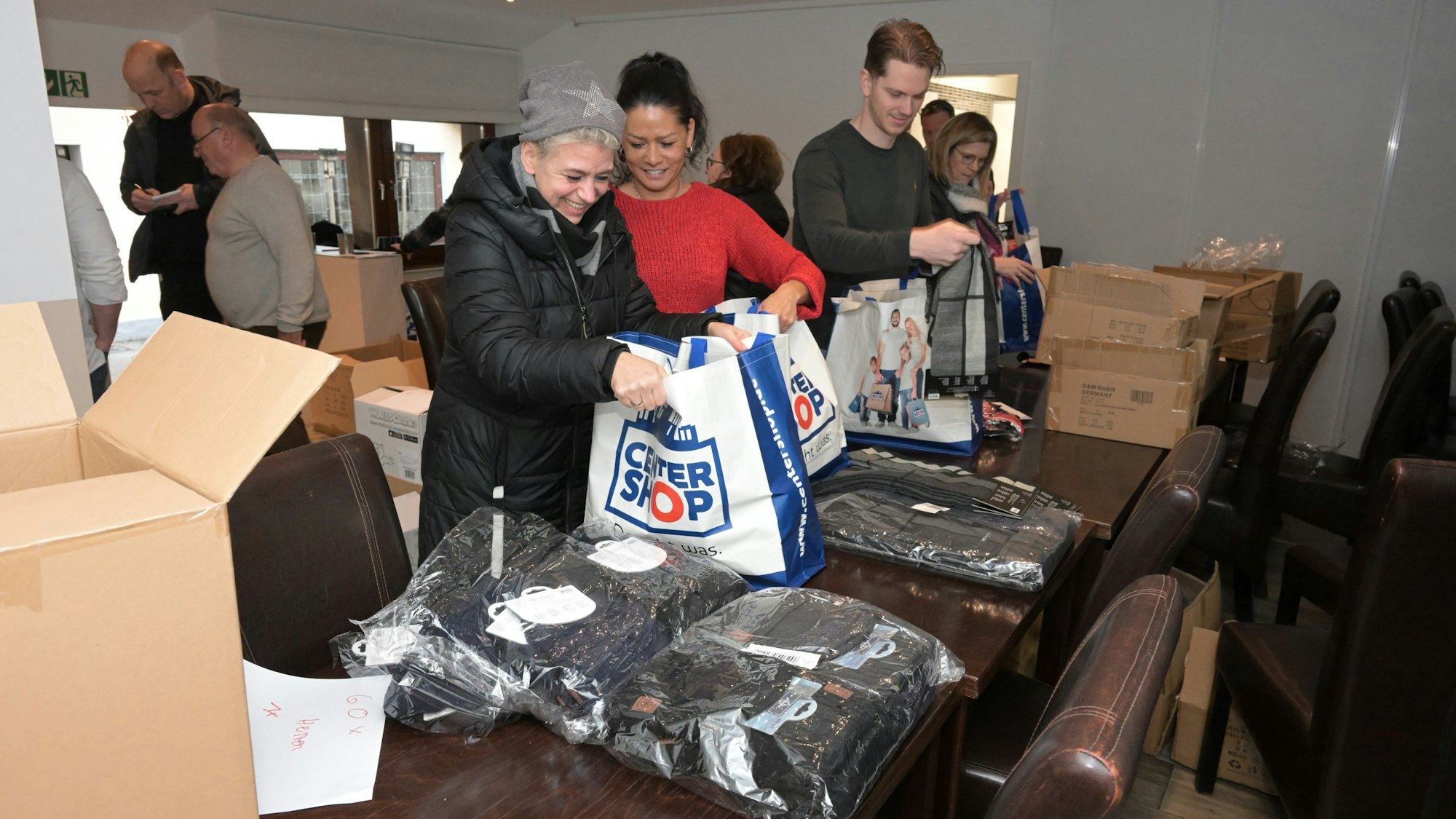 Freiwillige Helfer packen Geschenketaschen mit Hilfreichem im Winter für die wohnungslosen Gäste des besonderen „Neujahrsempfang“.
