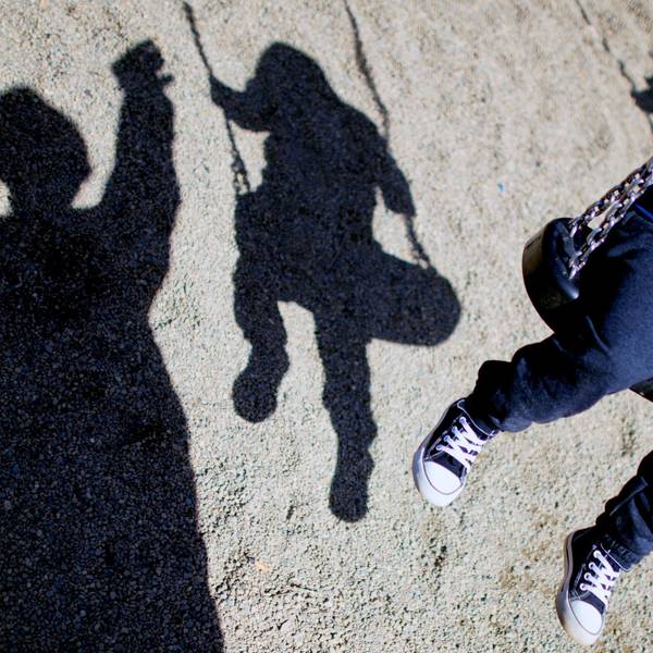 Zu sehen ist ein Kind auf einer Schaukel und sein Schatten, daneben ein weiterer Schatten eines Erwachsenen.