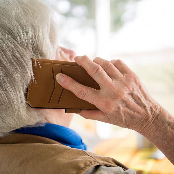 Eine Seniorin telefoniert mit ihrem Smartphone