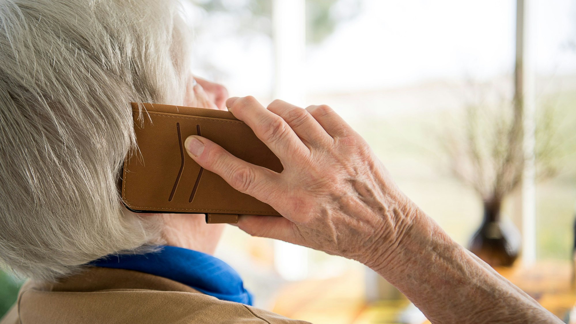 Eine ältere Dame telefoniert mit einem Smartphone.