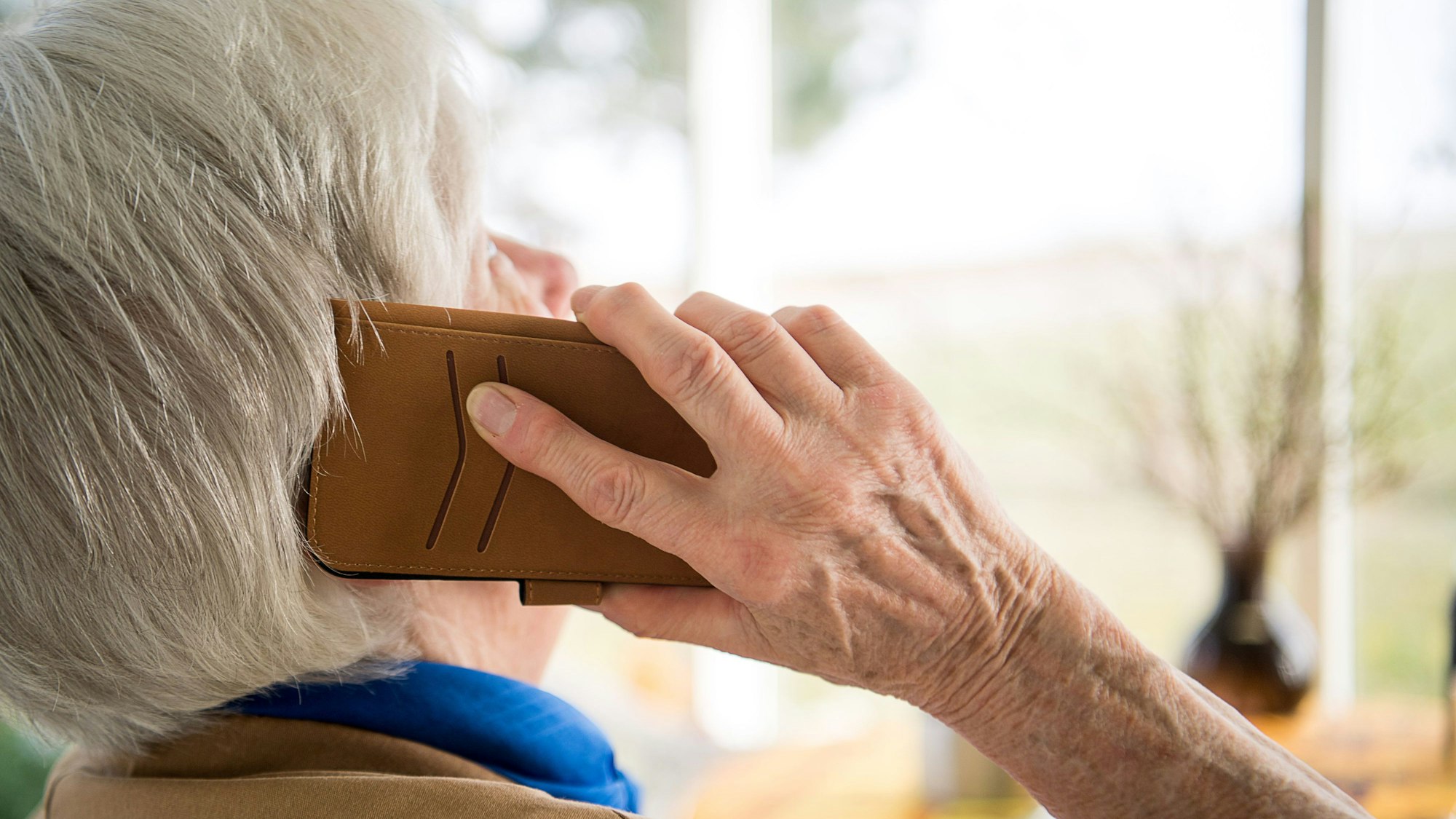 Eine Seniorin telefoniert mit ihrem Smartphone